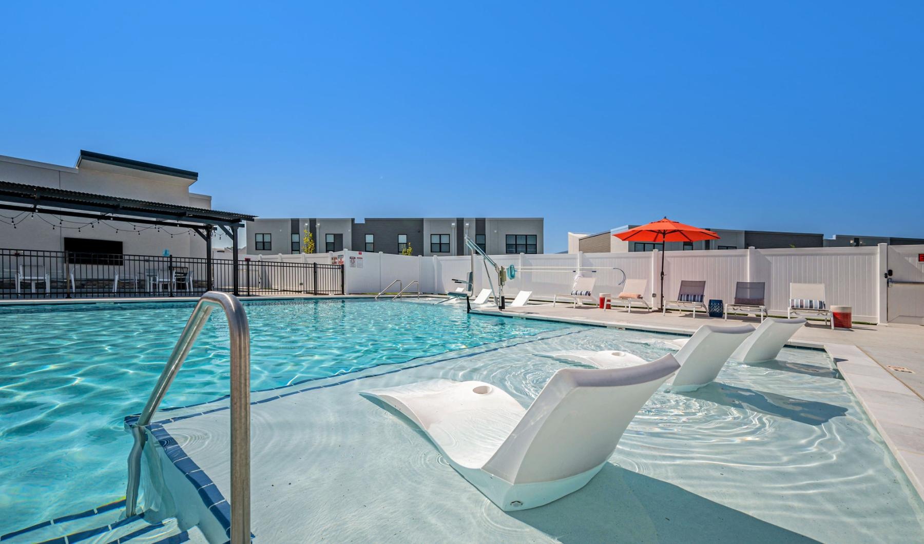 Relax and unwind poolside a pool with a slide in it